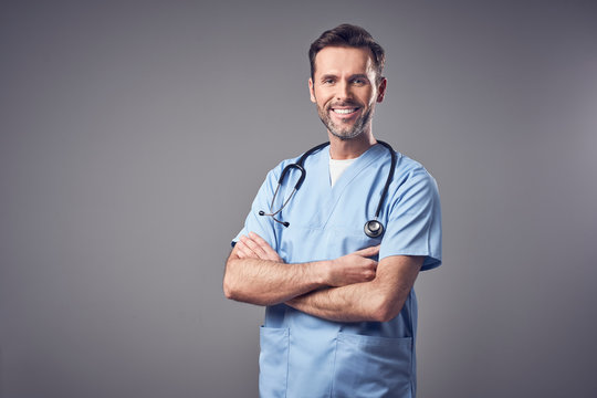 Happy doctor in blue uniform smiling isolated