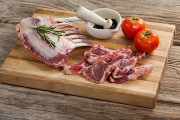 Rib rack, rib chops and ingredients on wooden board