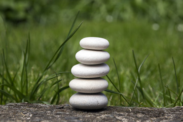 Obraz na płótnie Canvas Harmony and balance, five simple pebbles tower in the grass, simplicity