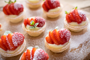 mini strawberry tarts on wood background