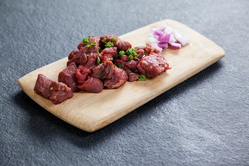 Diced beef and onions on wooden board