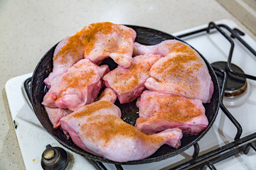 Juicy chicken pieces with spices are fried in a pan in oil on the stove
