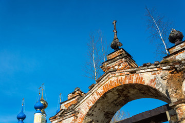Obraz premium Old Church archway, overgrown with birches, Russia.