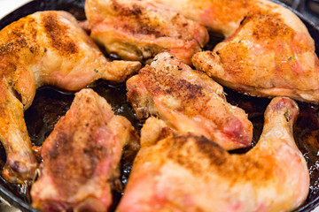 Juicy chicken pieces with spices are fried in a pan in oil on the stove
