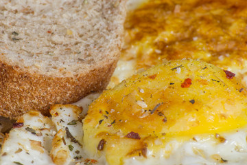 Closeup of fried eggs and bread with seasoning. Delicious and healthy breakfast.