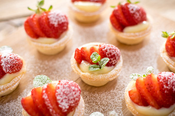 mini strawberry tarts on wood background