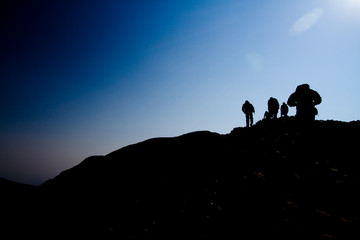 Silhouette of Men Hiking a Mountain