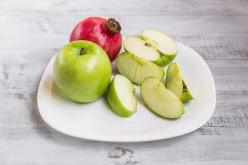 Fresh apples and pomegranate on the table. Ecological wooden background.