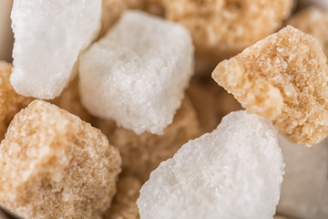White sugar and brown sugar cane cubes. Close up with selective focus
