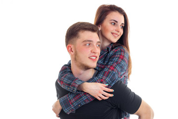 beautiful young girl hugs a guy's shoulders and they're smiling