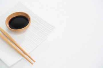 Chopstick and soy sauce on white plate