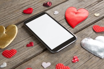 Mobile phone surrounded with heart shape decoration