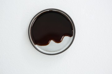 Chocolate syrup on plate against white background