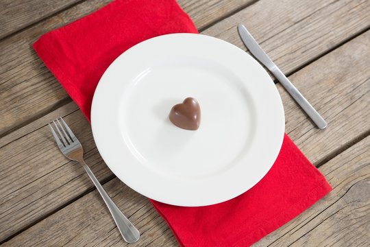 White plate with red heart chocolate in center