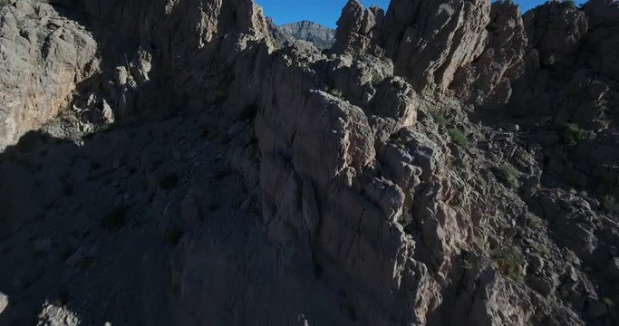 Flying through a notch in a ridge of the rocky, arid desert mountains of Nevada's Red Rock Canyon