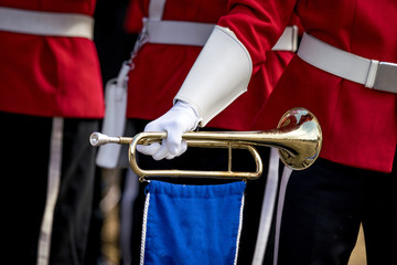 Soldier in red uniform holding a golden trumpet