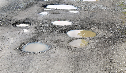Potholes filled by water on a rural unpaved road