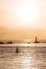 Sunset at lands end in Cornwall with clouds and sailboat