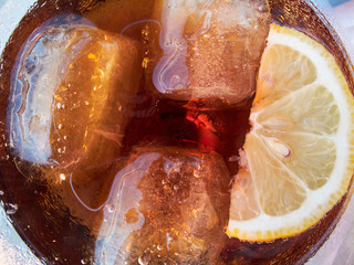 Soft drink with cola and a slice of lemon (top view)