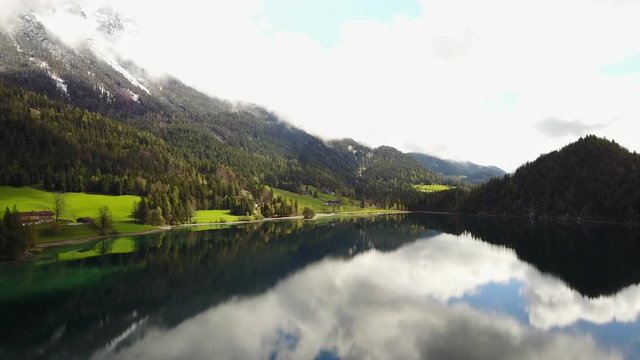 Aerial: flying over Hintersteiner Mountain lake with clear water in Austria and beautiful cloud reflections