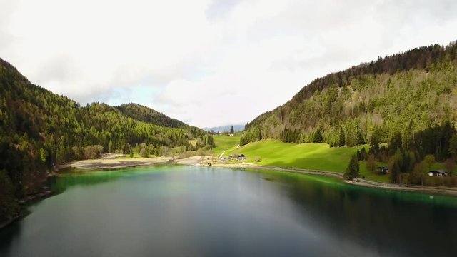 Aerial: flying over Hintersteiner Mountain lake with clear water in Austria and beautiful cloud reflections