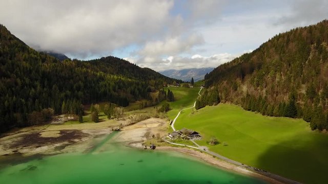 Aerial: flying over Hintersteiner Mountain lake with clear water in Austria and beautiful cloud reflections