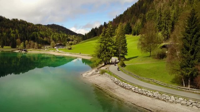 Aerial: flying over Hintersteiner Mountain lake with clear water in Austria and beautiful cloud reflections