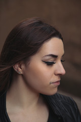 Closeup beauty portrait of a young sensual brunette girl with piercing on her face