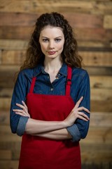 Portrait of waitress standing with arms crossed 