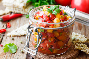 Tomato salsa with chili in a glass jar