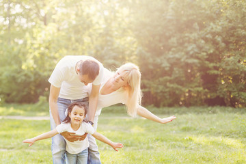 Fototapeta premium Happy family in nature. Dad, mom and daughter child flying a kite.