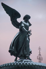 Angel statue with snow and sunset sky at Central Park