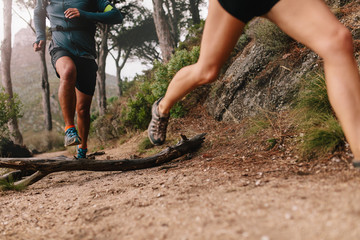 Runner legs running on mountain trail