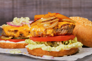 Beef burgers with red and yellow peppers, napa cabbage, tomato and cheddar