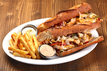 chicken sandwich with cheese and potatoes and sauce