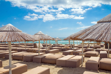 Sunbeds with umbrellas on white sand beach in Villasimius beach, Sardinia island, Italy