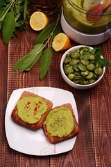 Toast with bean paste and boiled broad beans on wooden background.