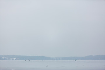 Rybacy łowiący ryby na zamarzniętej tafli jeziora © Leszek