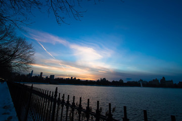 sunset sky and buildings behind Jacqueline Kennedy Onassis Reservoir, Central Park 