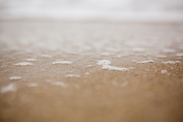 Fototapeta na wymiar Mokry piasek od fal na plaży