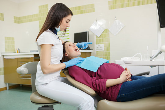 Dentist checking pregnant woman's teeth