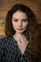 Portrait of woman standing with arms crossed in café