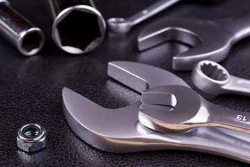 Fototapeta premium Spanners of various sizes, on dark abstract background.