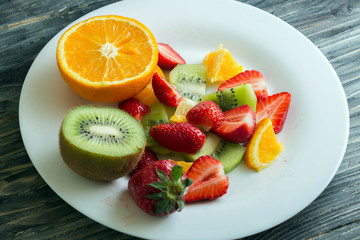 Sliced fruit on a white plate. Delicious dessert. Healthy food.