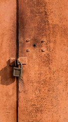 abstract background with holes, and lock screws, and the texture of rust orange-brown with spots. The vertical frame.