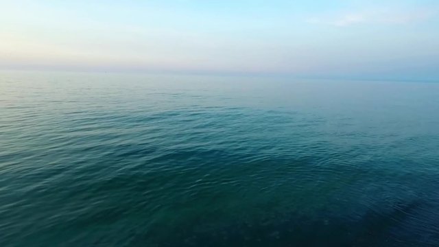 Aerial birds eye view looking down at sea waves crashing down. Green and blue sea top view drone drone footage  