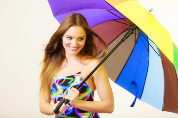 Fototapeta premium Happy woman posing in swimsuit and colorful umbrella