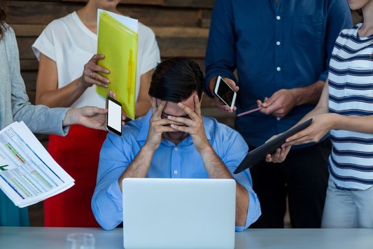 Frustrated male business executive sitting with laptop