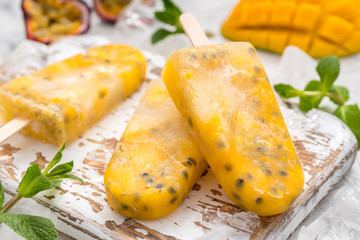 Homemade frozen popsicles with fresh mango and passion fruit