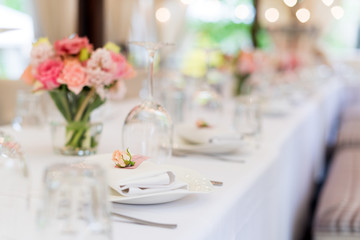 Flower table decorations for holidays and wedding dinner. Table set for holiday, event, party or wedding reception in outdoor restaurant.